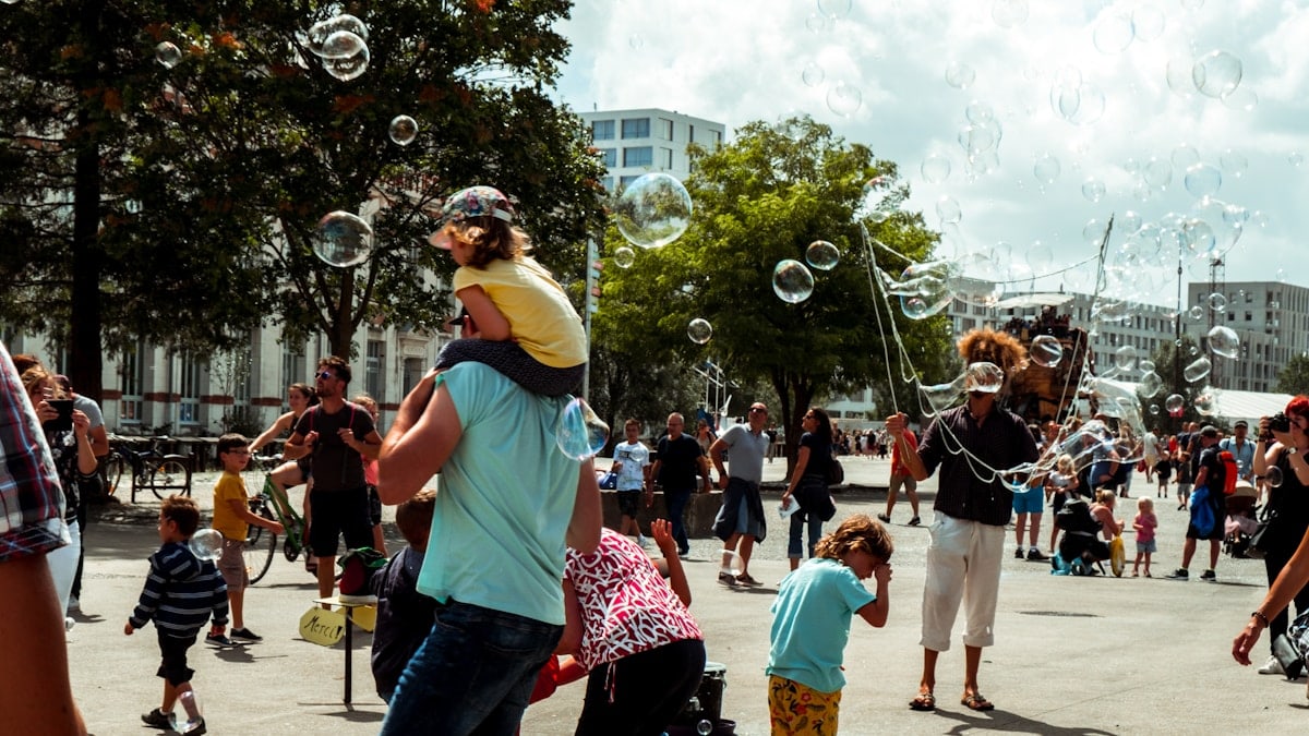 Family playing in the square with soap bubbles